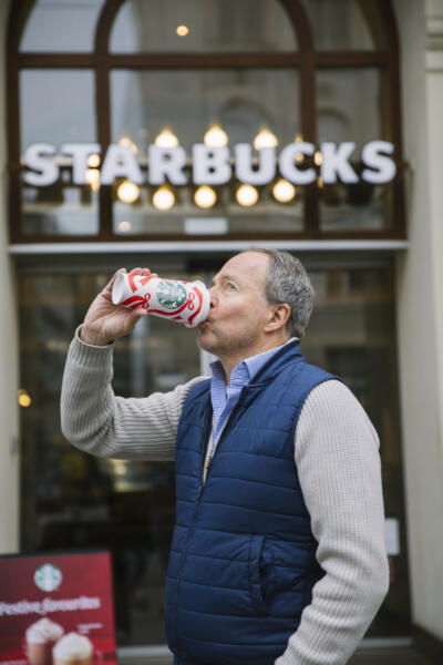 Bernhard trinkt einen Kaffee vor Starbucks in der Wiener Innenstadt