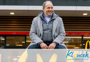 Bernhard Kloucek sitzt auf einemMcDonald-Zeichen